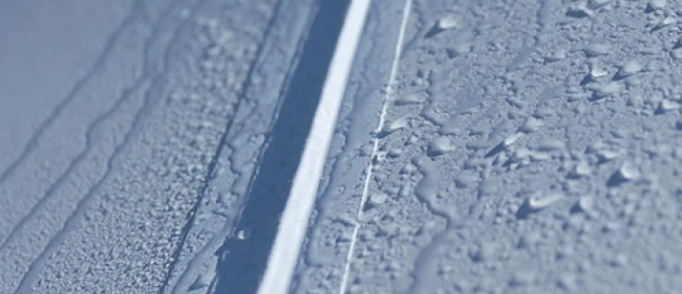 ปิด-up of a welded, waterproof stretch tent seam with water beading off the treated fabric surface